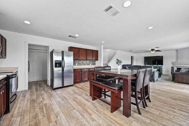 Kitchen featuring stainless steel fridge, black / electric stove, a ceiling fan, light wood-style floors, and recessed lighting | Image 16
