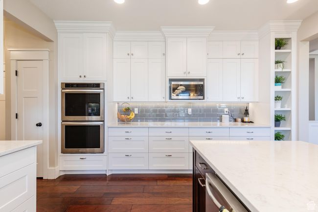 Kitchen with stainless steel appliances, dark wood-type flooring, white cabinetry, and recessed lighting | Image 14