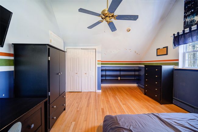 Bedroom 3 with a baseboard heating unit, light wood-style floors, and lofted ceiling | Image 30
