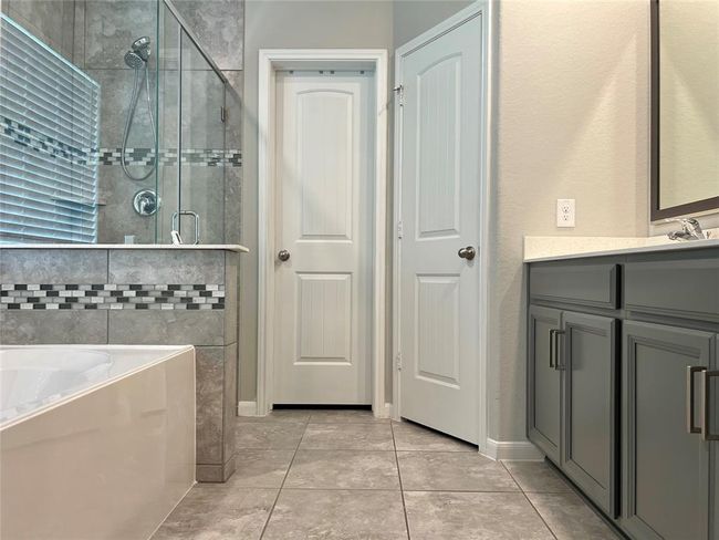 Unwind in your spa-like bathroom with a garden tub, separate shower, dual vanities, and a spacious walk-in closet. | Image 13