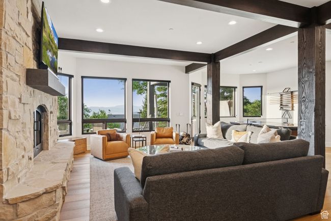 Living room with beamed ceiling, light wood-style floors, plenty of natural light, recessed lighting, and a stone fireplace | Image 47