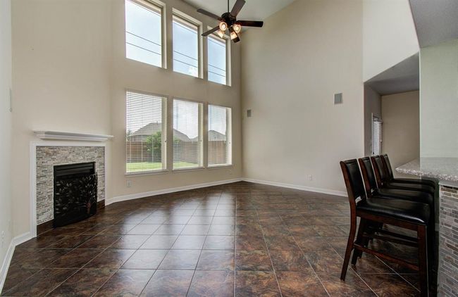 Large open living room with gas fireplace, and tile floors through out most of downstairs living space except master bedroom and study. | Image 15