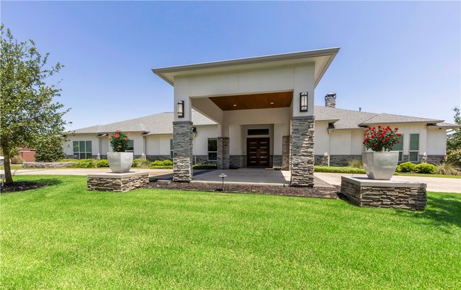 Rear view of property featuring stone siding, stucco siding, a yard, and french doors | Image 4