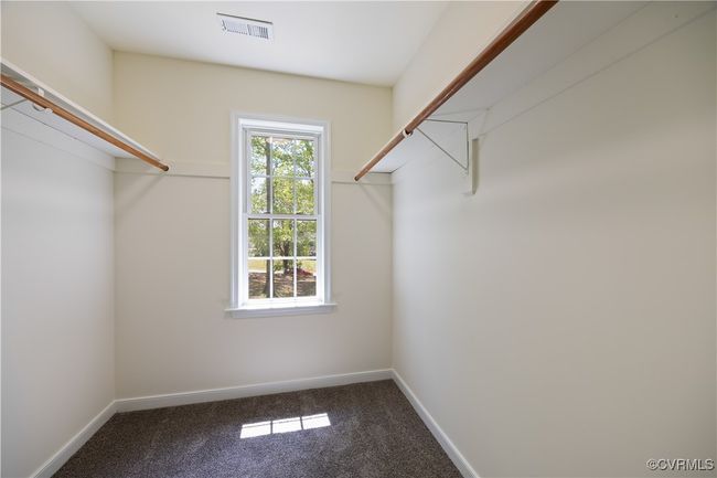 Walk in closet with visible vents and carpet flooring | Image 24
