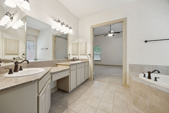 Full bath with double vanity, tile patterned flooring, a garden tub, ceiling fan, and baseboards | Image 21