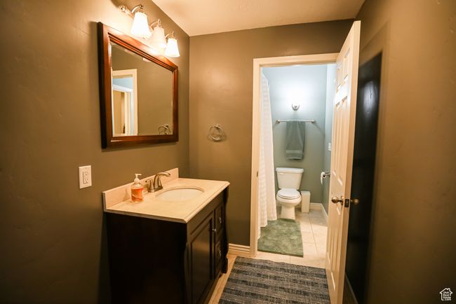 Bathroom featuring toilet, tile patterned flooring, vanity, and baseboards | Image 35