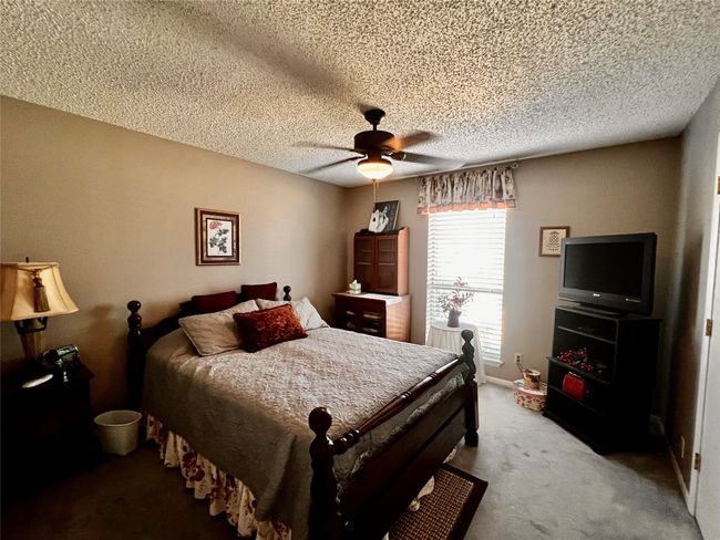 Bedroom featuring carpet, a textured ceiling, and ceiling fan | Image 8