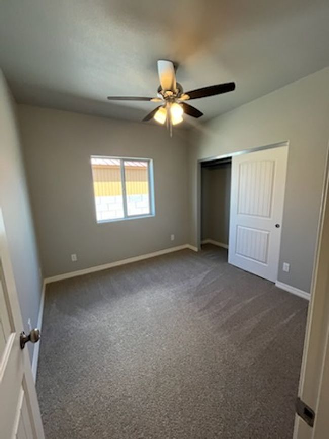Unfurnished bedroom with dark carpet, baseboards, and a closet | Image 28