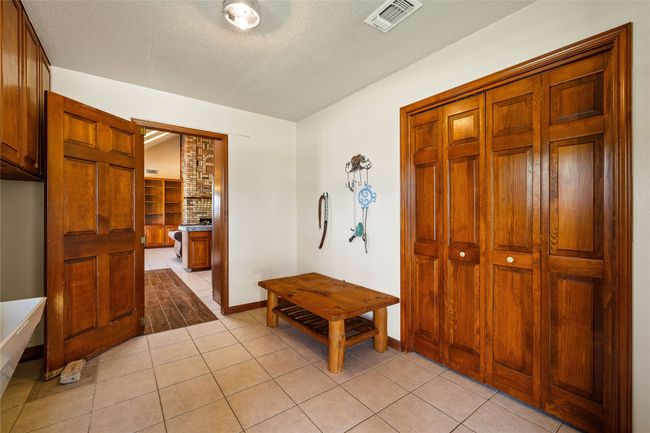 Foyer with light tile patterned floors, a textured ceiling, and baseboards | Image 18