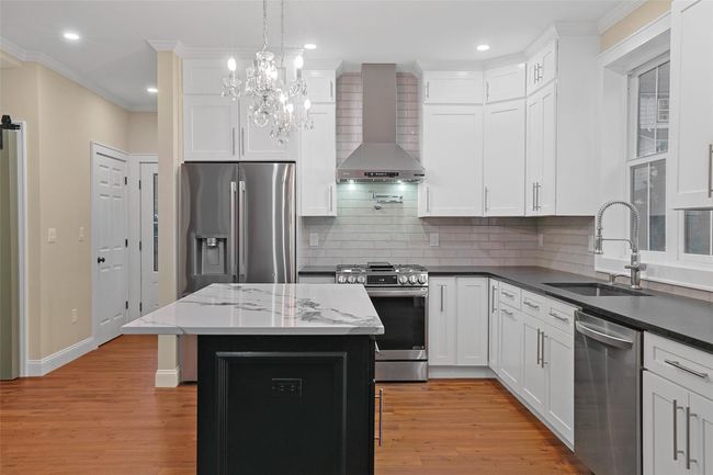 Kitchen features Kitchen features floor to ceiling wood Shaker cabinets and quartz countertops. | Image 10