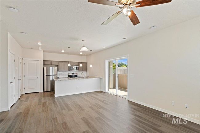 Unfurnished living room with dark wood-style flooring, a textured ceiling, recessed lighting, and a ceiling fan | Image 5