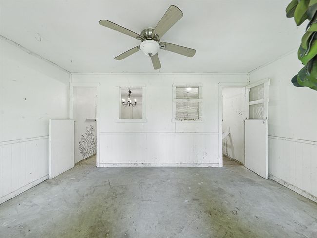 Unfurnished bedroom with unfinished concrete flooring and ceiling fan with notable chandelier | Image 32
