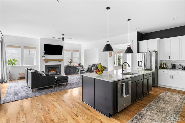 Kitchen featuring a sink, appliances with stainless steel finishes, white cabinets, light wood finished floors, and ceiling fan | Image 13