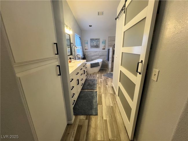 Bathroom with double vanity, wood finished floors, and a soaking tub | Image 32