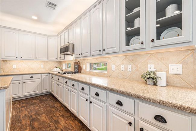 There is undermount lighting for task lighting, upper cabinet lighting for added ambiance and transom windows for natural light, plus pretty glass front cabinets for display of your favorite things! | Image 21