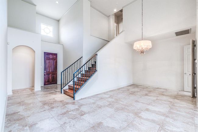 Dining space has kitchen connection and beautiful chandelier. Notice the updated iron railings on staircase. | Image 14