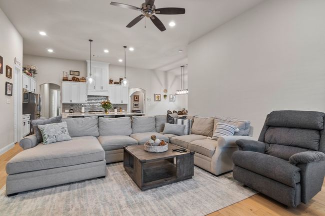 Living area with baseboards, light wood-style flooring, recessed lighting, arched walkways, and ceiling fan | Image 11