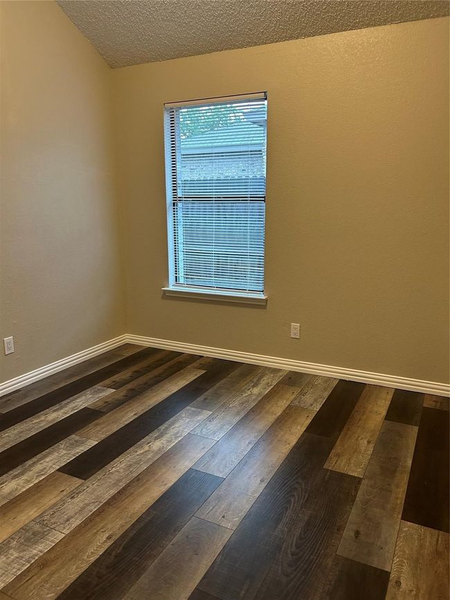 Empty room with hardwood / wood-style flooring and a textured ceiling | Image 16