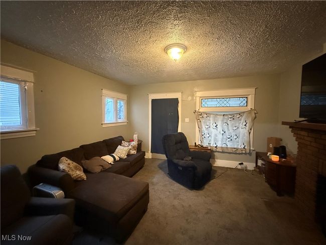 Living area with carpet flooring and a textured ceiling | Image 16