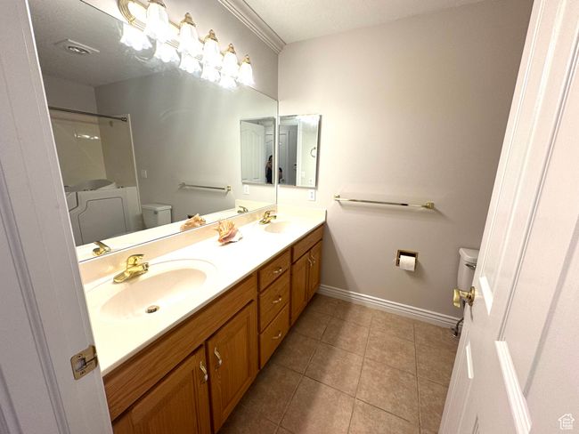 Main level bathroom with dual sink and tile floor. | Image 16