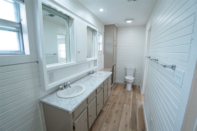 Bathroom featuring a sink, toilet, wood finished floors, and double vanity | Image 6