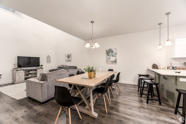 Dining space with dark wood-type flooring, baseboards, and a notable chandelier | Image 11
