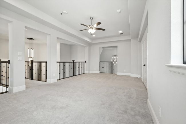 Empty room featuring a chandelier, a ceiling fan, carpet, and a smoke detector | Image 29