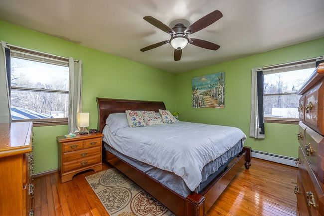 Bedroom with hardwood flooring, multiple windows, and baseboard | Image 13