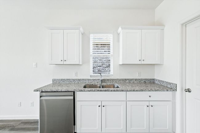 Kitchen featuring dishwasher, white cabinets, light stone counters, and wood finished floors | Image 9