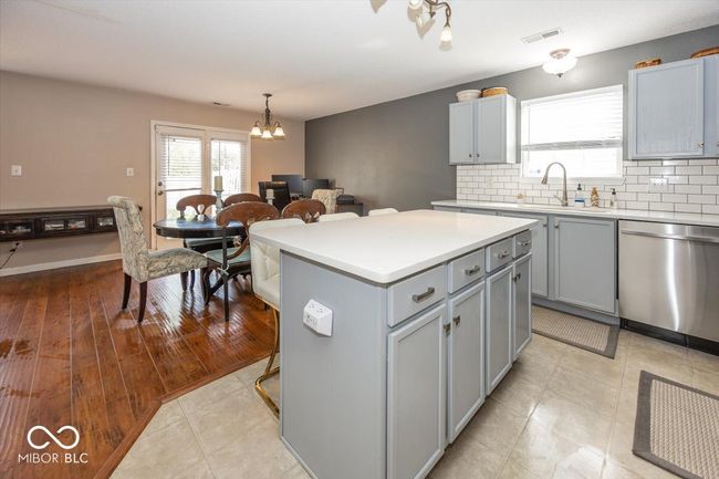 kitchen featuring a sink, dishwasher, gray cabinets, an inviting chandelier, and visible vents | Image 10