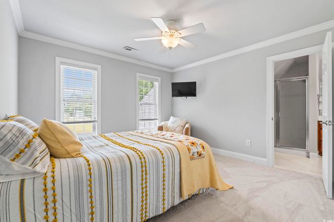 Bedroom featuring baseboards, crown molding, light colored carpet, and a ceiling fan | Image 19