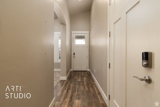 Doorway to outside featuring arched walkways and dark wood-type flooring | Image 6