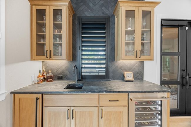 Indoor wet bar featuring tasteful backsplash and ice maker and beverage cooler | Image 11