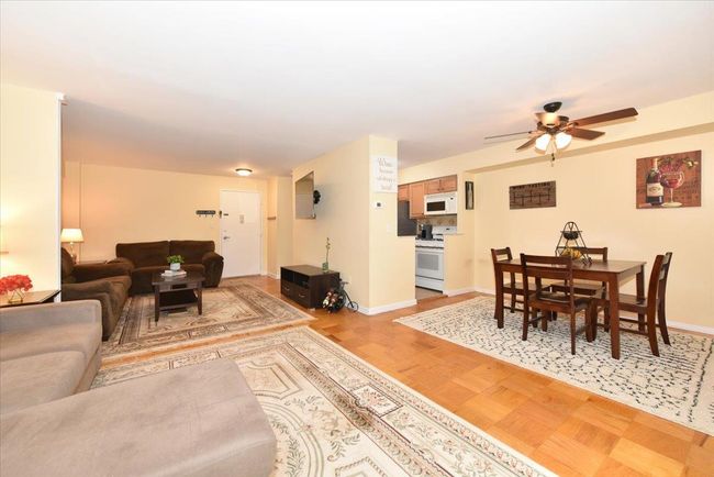Living room with a ceiling fan and light wood-style floors | Image 11