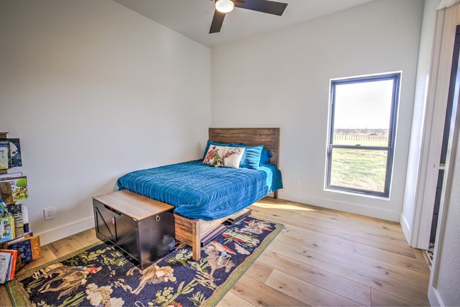 Bedroom with ceiling fan, baseboards, and wood-type flooring | Image 23