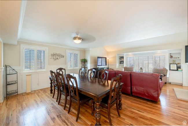 Dining space with a decorative wall, wainscoting, light wood-type flooring, and ornamental molding | Image 16