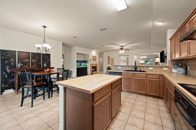 Efficient kitchen layout featuring fridge, microwave, and nearby pantry access. | Image 20
