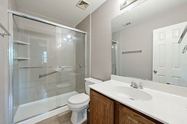 Full bathroom with a stall shower, vanity, and tile patterned flooring | Image 29