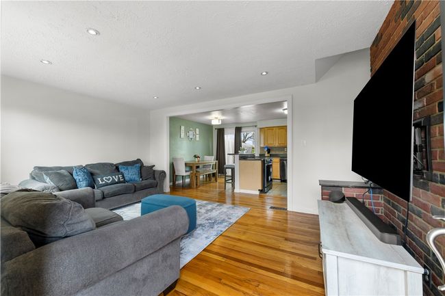This house has an open floor plan, hardwood floors that extend into the dining area, and the kitchen area is open as well. | Image 5