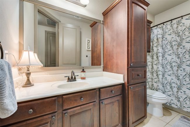 Bathroom with vanity, tile patterned flooring, and a shower with shower curtain | Image 35