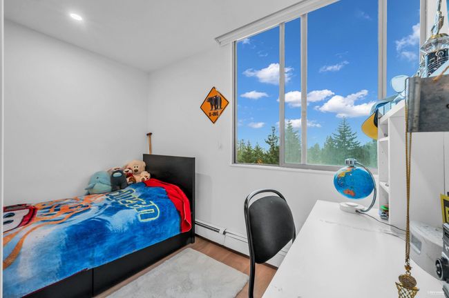 Bedroom with wood finished floors and a baseboard heating unit | Image 26