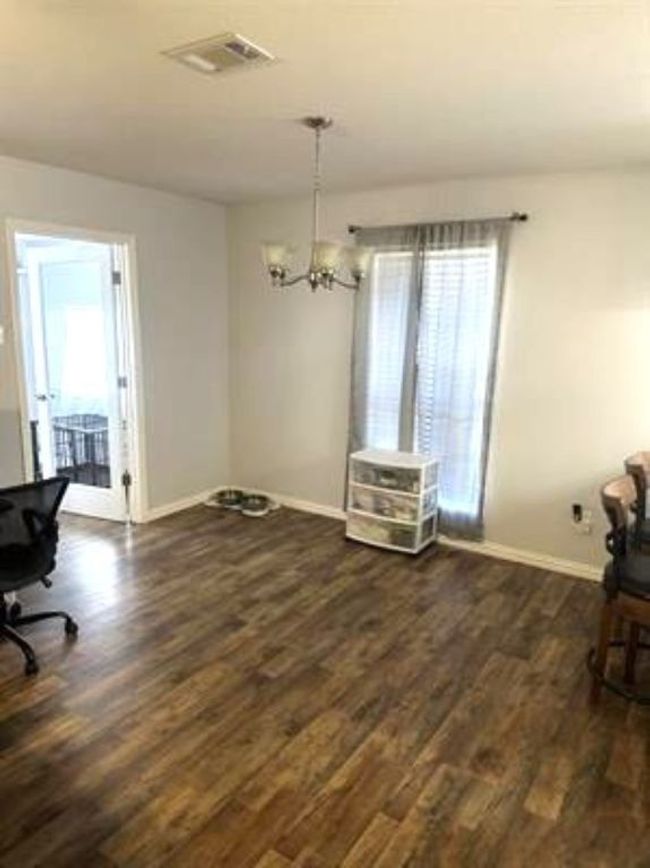 Dining space with a notable chandelier, dark wood-type flooring, visible vents, and baseboards | Image 9