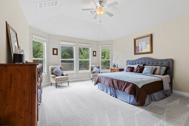 Bedroom with multiple windows, light colored carpet, baseboards, and lofted ceiling | Image 14