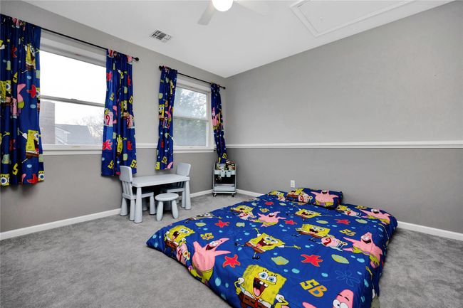 Carpeted bedroom featuring visible vents, baseboards, and ceiling fan | Image 12