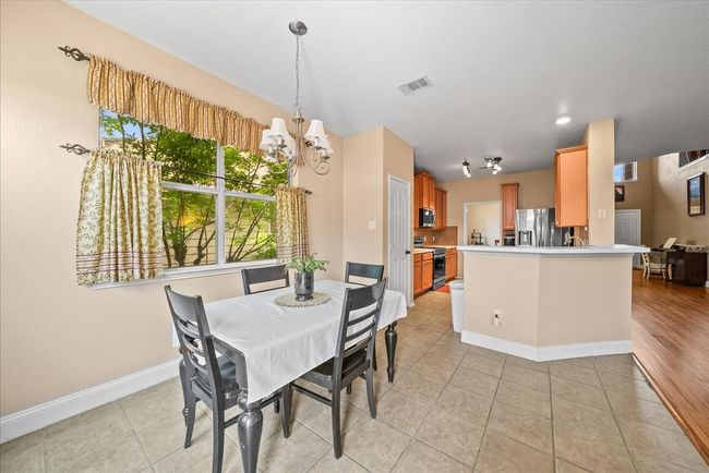 Dining area with a chandelier, light tile patterned floors, and baseboards | Image 21