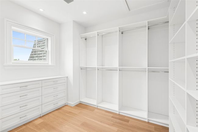 Walk in closet featuring light wood-style flooring and attic access | Image 25