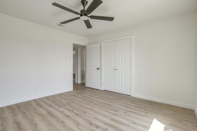Unfurnished bedroom with wood finished floors, a closet, and a ceiling fan | Image 18