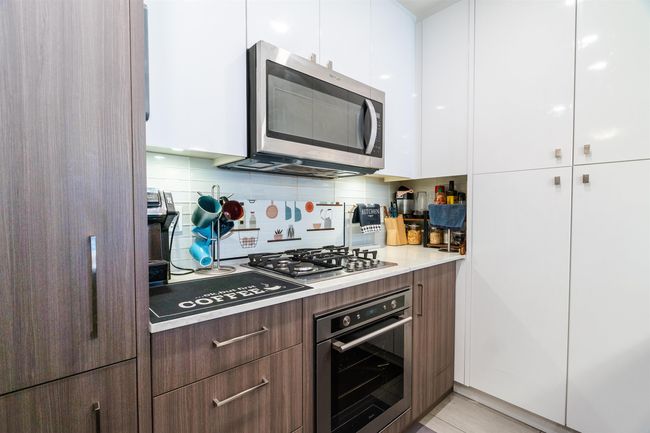 Kitchen with modern cabinets, white cabinets, stainless steel appliances, and tasteful backsplash | Image 6