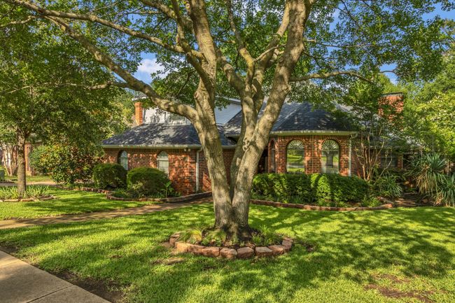 View of front of home with a chimney, brick siding, a front lawn, and a shingled roof | Image 33