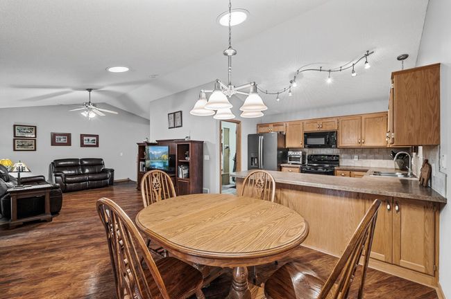 The dining area flows seamlessly between the kitchen and living room, offering ample space for hosting larger gatherings. | Image 6